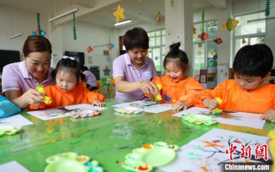 在肥西县山南镇中心幼儿园，孩子们在老师的指导下作画。陈家乐 摄