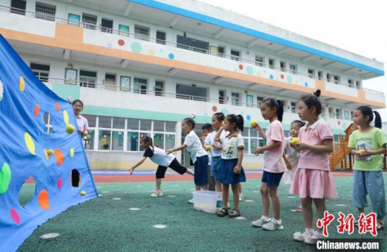 在肥西县山南镇中心幼儿园，孩子们在玩布洞投球游戏。陈家乐 摄