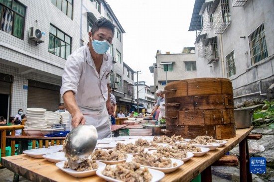 7月29日，在重庆市綦江区安稳镇，当地居民在“苗家伏羊节”上准备羊肉长桌宴。新华社记者 唐奕 摄