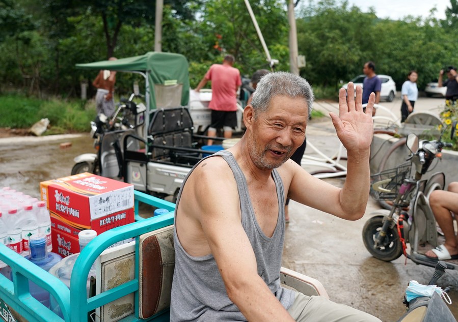 8月5日，从安置点回来的北京市房山区青龙湖镇口头村村民高大爷领到生活物资准备回家。新华社记者 张晨霖 摄