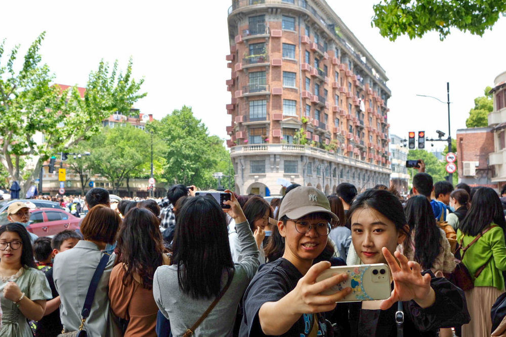 游客在上海武康大楼前拍照留念（2023年4月30日摄）。新华社记者 辛梦晨 摄