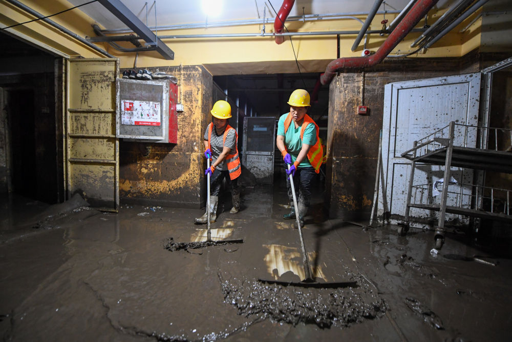 8月12日，在北京市门头沟区医院，因水灾影响无法从事原本工作的受灾群众组成清淤队伍，清理医院地下室的淤泥和垃圾。新华社记者 鞠焕宗 摄