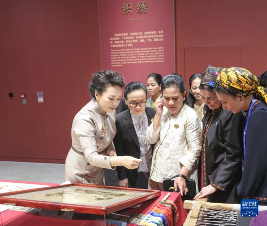  10月18日上午，国家主席习近平夫人彭丽媛邀请出席第三届“一带一路”国际合作高峰论坛的外方领导人夫人参观中国工艺美术馆（中国非物质文化遗产馆）。这是彭丽媛同外方领导人夫人观看刺绣。新华社记者 殷博古 摄