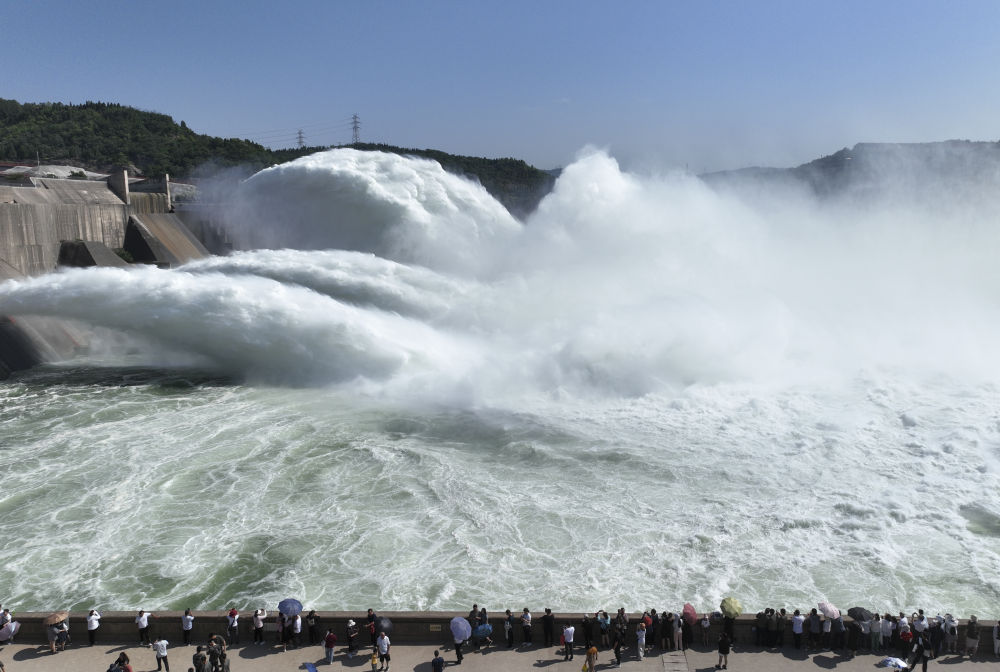 游客在黄河小浪底水利枢纽工程出水口观看调水调沙（2023年6月23日摄，无人机照片）。新华社发（苗秋闹 摄）