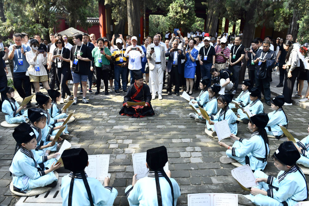 2023年6月27日，在曲阜孔庙，嘉宾和游客在聆听孩子们诵读《论语》。