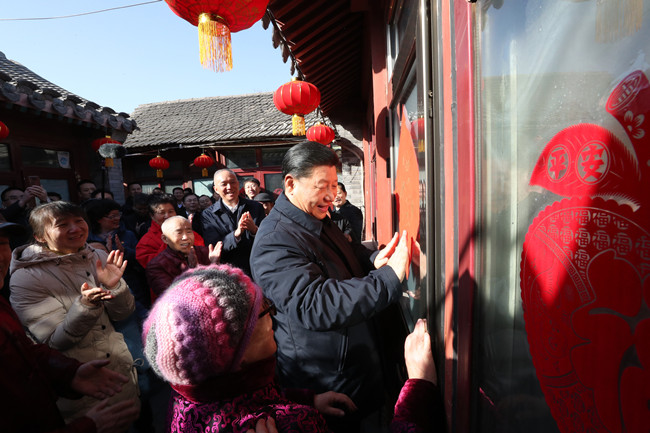 2019年2月1日上午，习近平总书记在前门东区草厂四条胡同32号院，高兴地拿起一幅“福”字，亲自贴到门上，给这里的老街坊们拜年。新华社记者鞠鹏摄