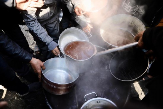  2月27日，在加沙地带北部的杰巴利耶难民营，人们领取食物。新华社发（穆罕默德·阿里摄）