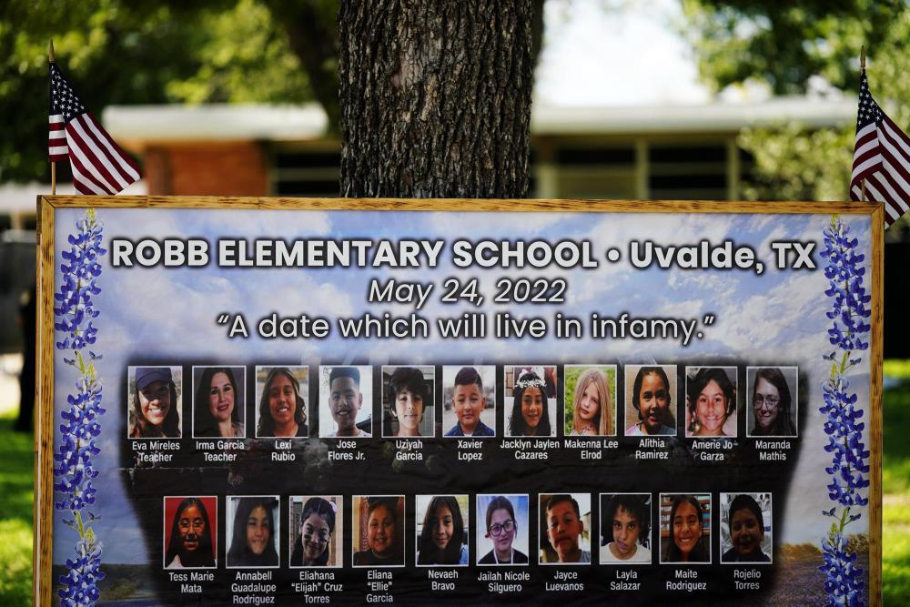 2023年5月24日，美国得克萨斯州小城尤瓦尔迪的原罗布小学摆放着校园枪击遇害者的照片。当日是美国尤瓦尔迪大规模校园枪击事件一周年。2022年5月24日，19名学生和2名教师在尤瓦尔迪市罗布小学枪击事件中遇难。新华社记者吴晓凌摄