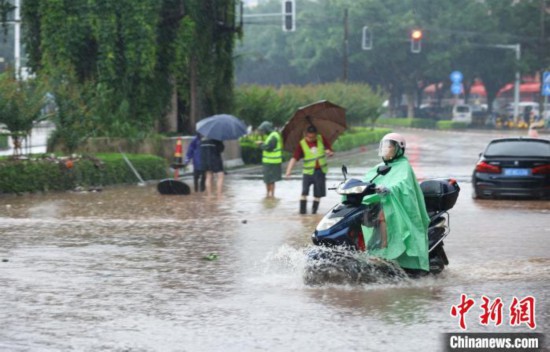 5月10日，广西沿海遭遇强降雨。图为钦州市民众在积涝中出行。陆敏 摄