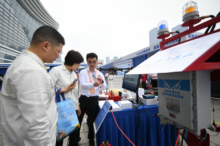 6月16日，在全国“安全宣传咨询日”主场活动上，四川省安全科学技术研究院工作人员（右一）向参观者介绍“有限空间作业实时风险管控系统”。新华社记者胥冰洁摄