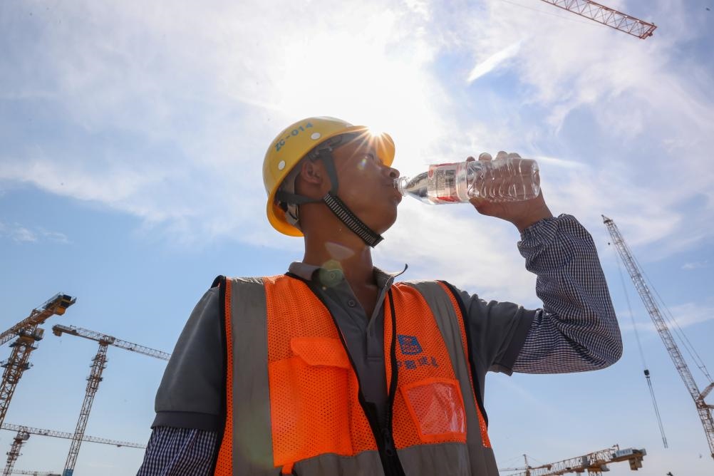 6月18日，在江苏省无锡市奥体三期项目施工现场，中建二局工人在喝水解暑。新华社发（朱吉鹏 摄）