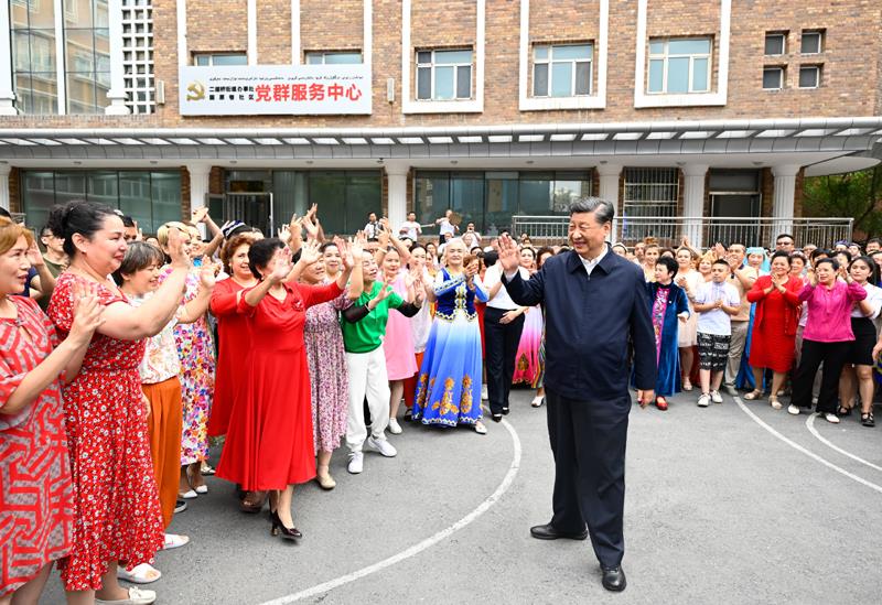 2022年7月13日，习近平总书记在新疆乌鲁木齐市天山区固原巷社区考察时，向各族群众挥手致意。