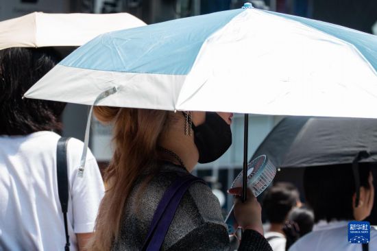 7月4日，人们在日本东京原宿的街道上等待红绿灯。新华社记者 张笑宇 摄