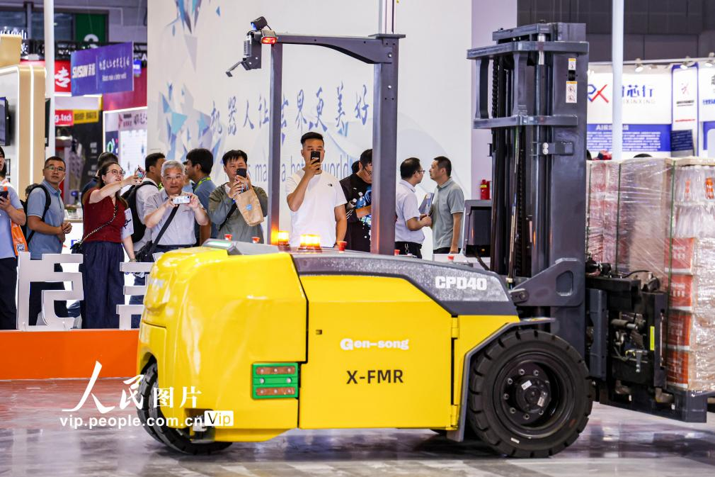 第24届中国工博会现场,观众观看叉取机器人作业演示。王初摄(人民图片网)